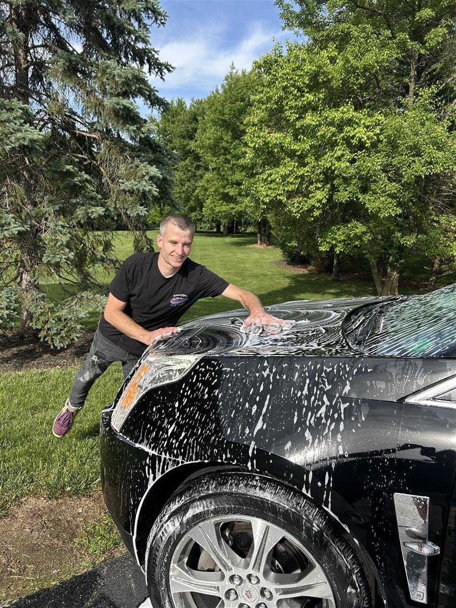 Owner hand-washing a soapy car